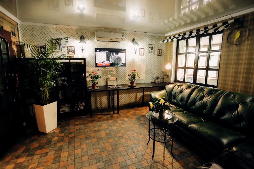 秋明Hostel Green City Tyumen的客厅配有真皮沙发和桌子