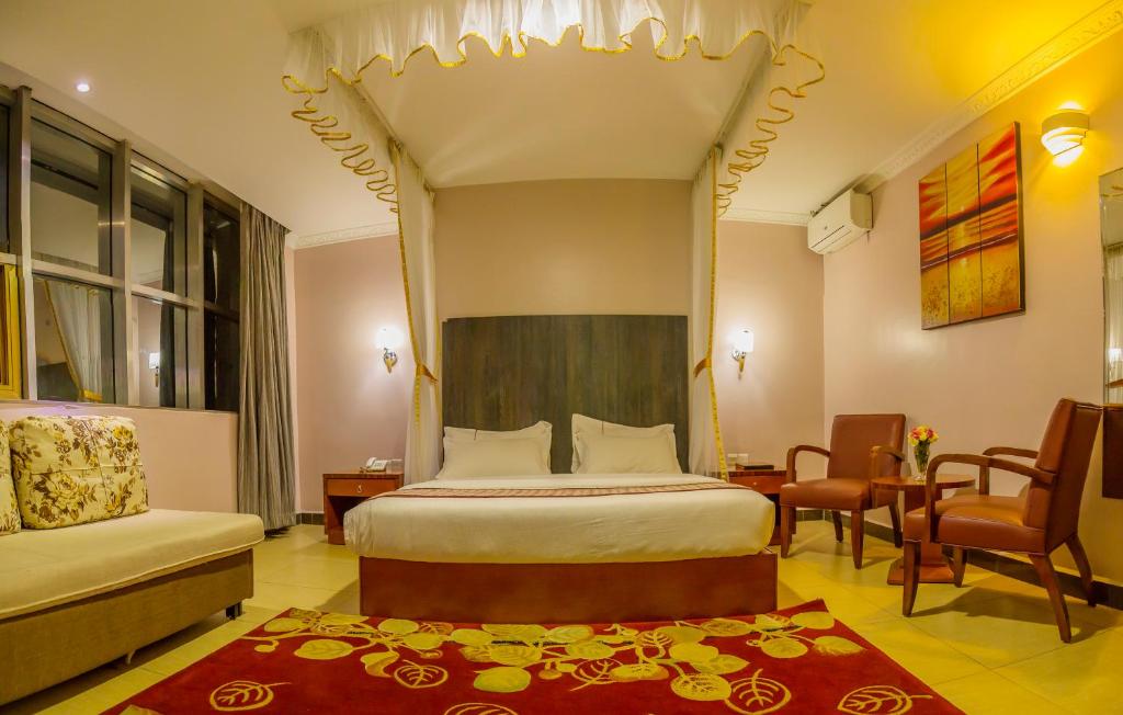 坎帕拉Russell Hotel的一间卧室配有一张床、一把椅子和一张桌子