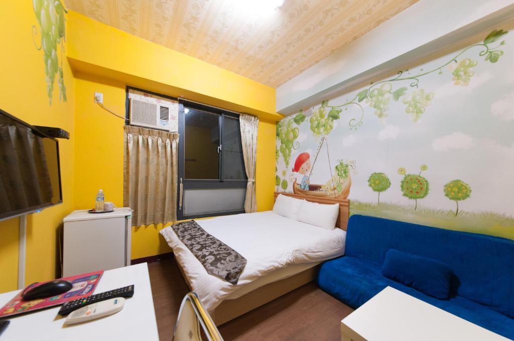 台中市逢甲客居的小房间设有床和蓝色的沙发
