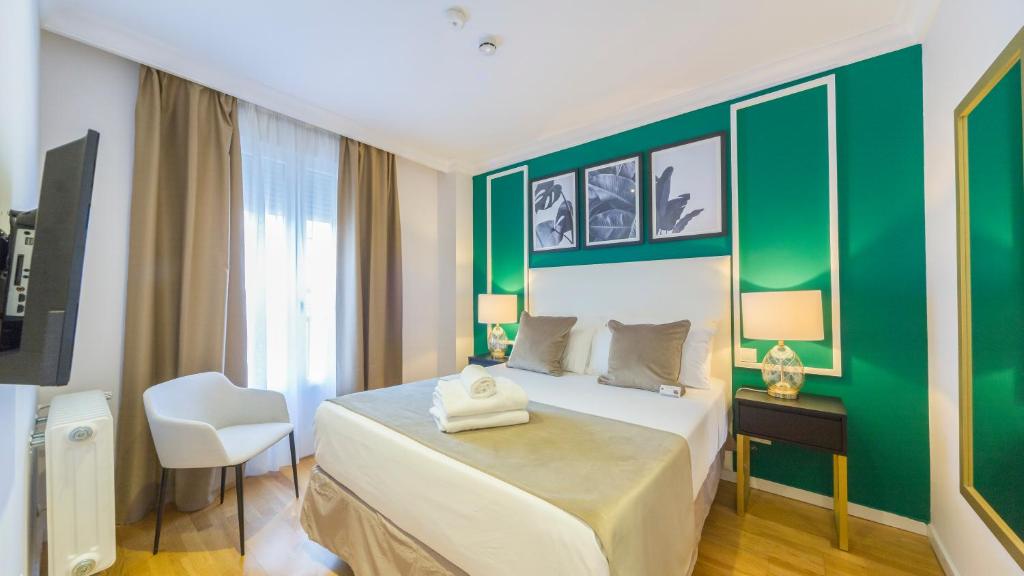 马德里TGH Gran Vía Apartments的一间卧室设有一张床和绿色的墙壁