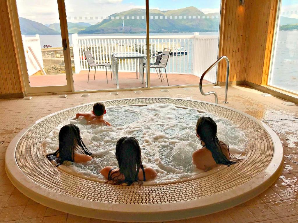 格伦科Holly Tree Hotel, Swimming Pool & Hot Tub的三个孩子在热水浴缸中