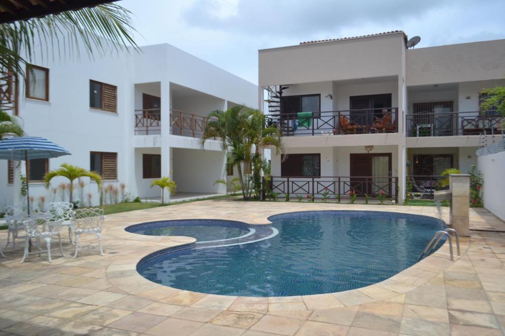 巴拉多库努Apartamento em Barra do Cunhaú的大楼前设有游泳池的酒店