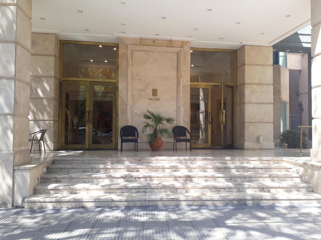 门多萨Millennium Departamento en Mendoza的大厅,建筑里有两把椅子和一棵植物