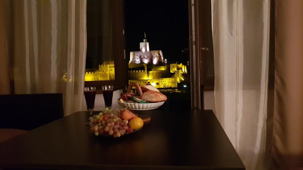 阿哈尔齐赫Hotel Rabati的一张桌子,放着一碗水果,享有城堡的景色