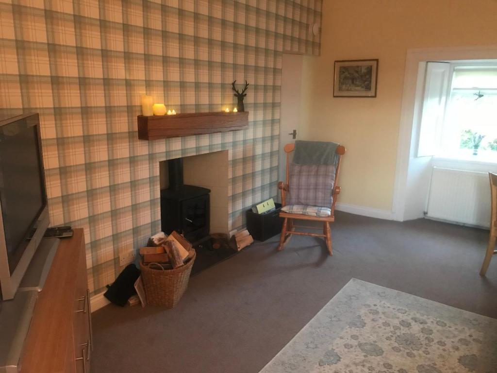 GartocharnGarden Cottage的客厅设有壁炉和椅子