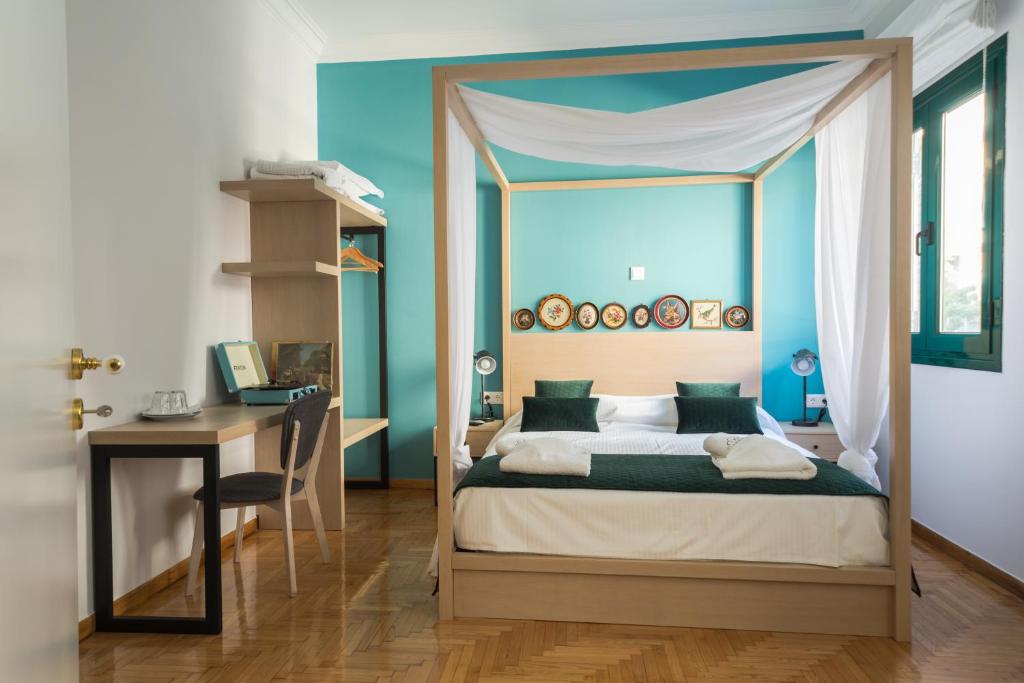 雅典Neratzia Rooms的一间卧室配有一张天蓬床和一张书桌