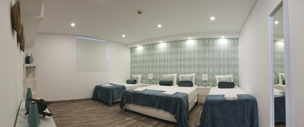 里斯本4U Lisbon VI Guesthouse Airport的一间客房内配有两张床的房间