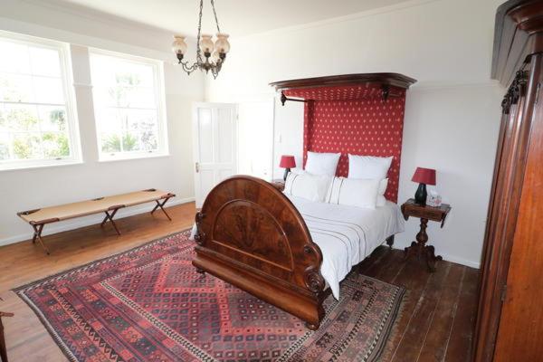 阿尔弗雷德港Cumberland House的一间卧室配有一张大床和红色床头板