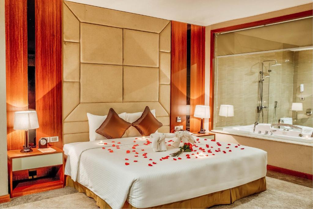 北宁孟坦奢华巴克宁酒店的一间卧室,床上有红色玫瑰