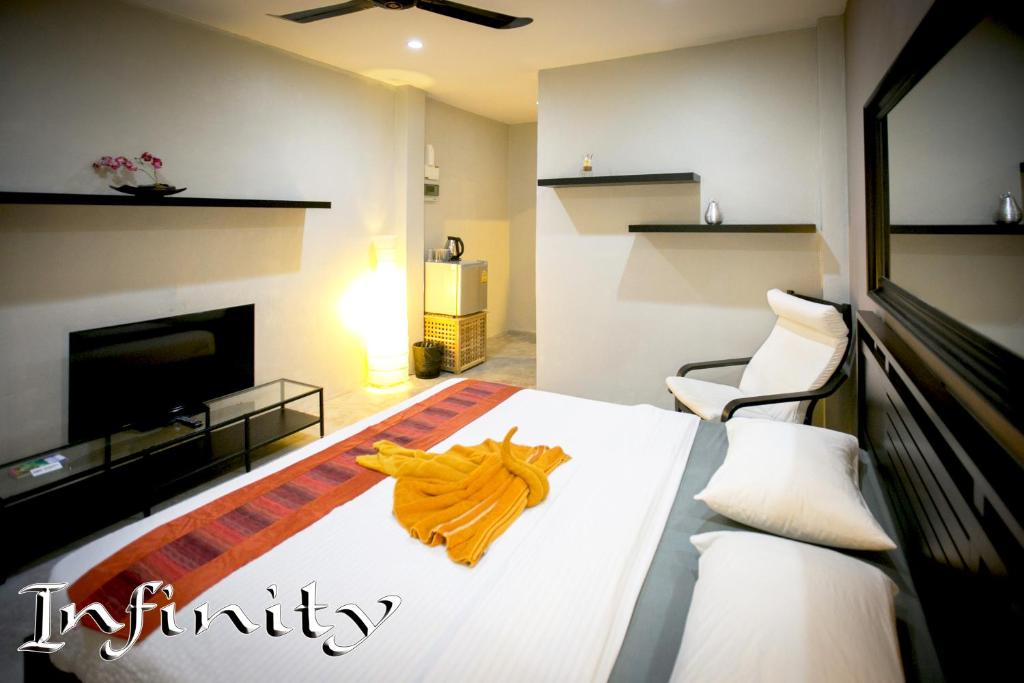 涛岛英菲尼迪盖斯特豪斯旅馆的一间卧室配有一张带橙色毛巾的床