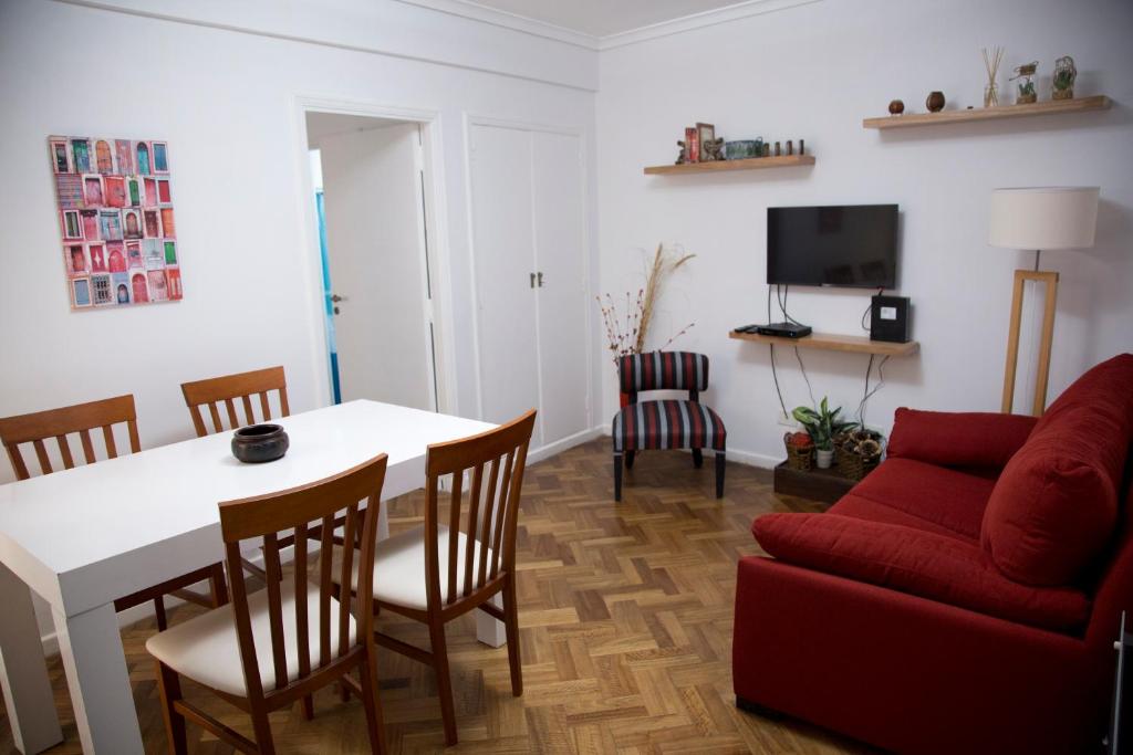 布宜诺斯艾利斯Small & Comfortable Apartment in Palermo的客厅配有桌子和红色沙发