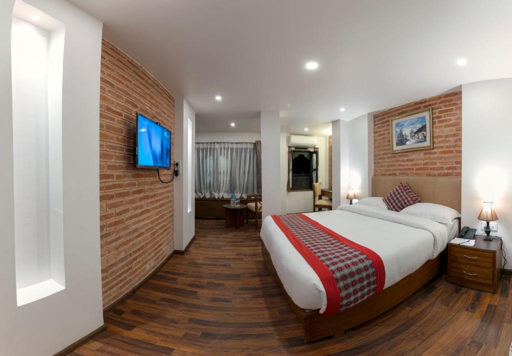 加德满都Kailash Kuti Inn的一间卧室设有一张大床和砖墙