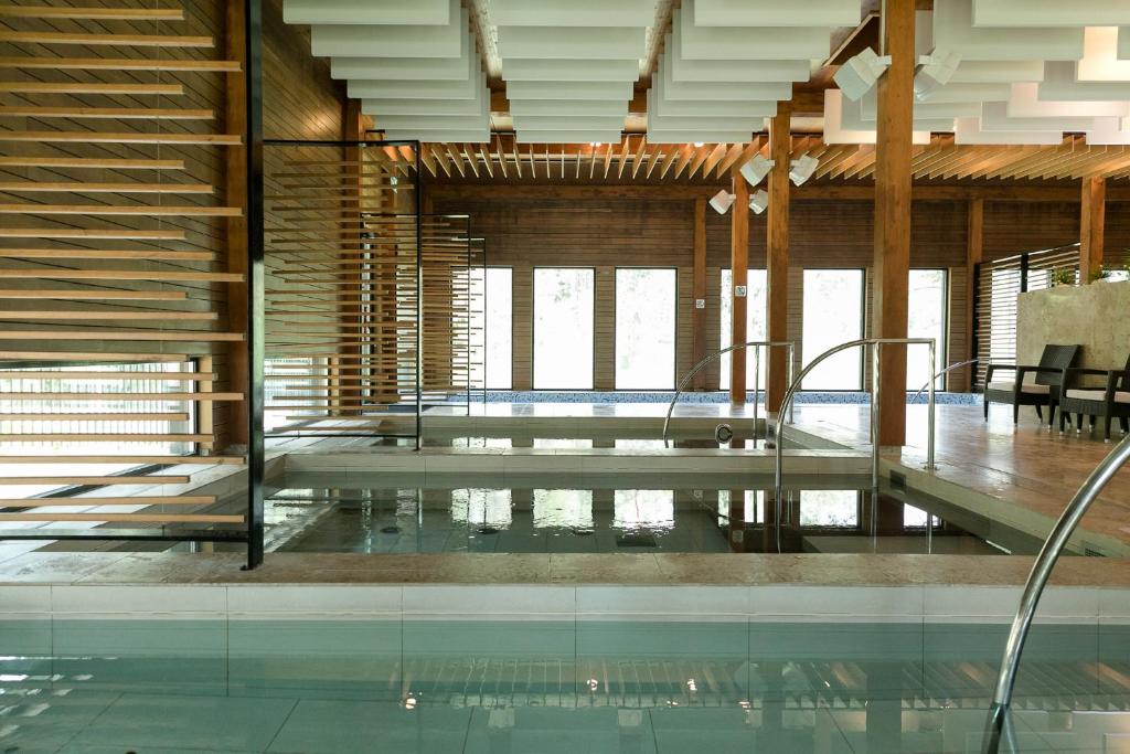 沃鲁库比亚自然Spa酒店的一座带玻璃地板和木制天花板的别墅内的游泳池