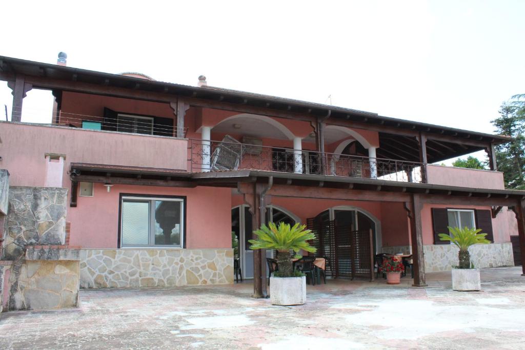 马丁纳弗兰卡Piccolo Ulivo 2的带阳台和棕榈树的大型红色房屋
