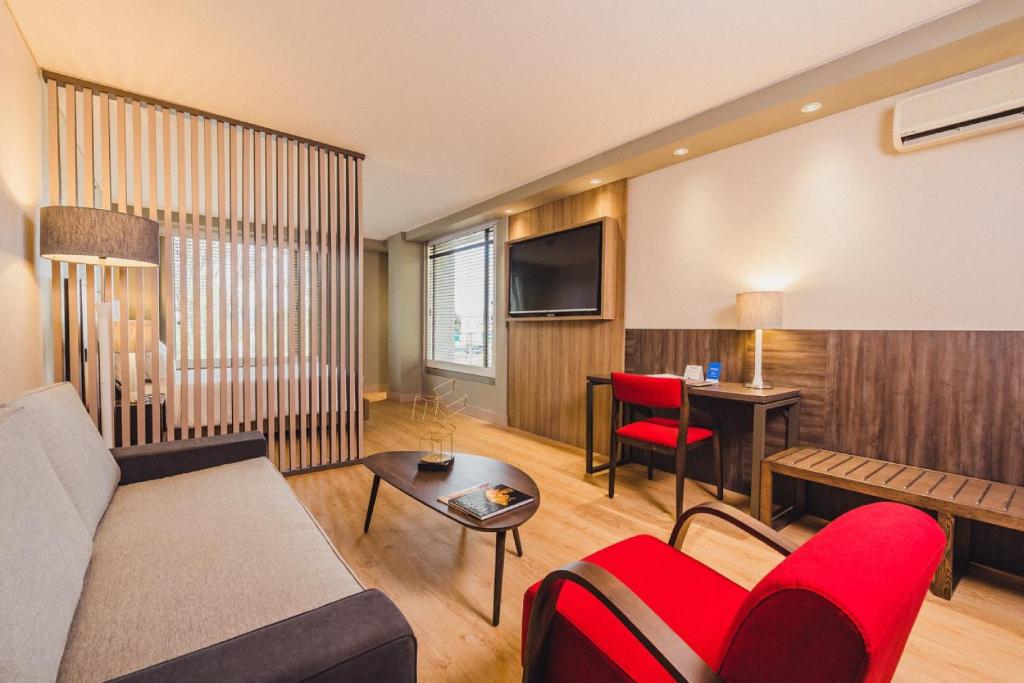 波哥大Hotel Habitel Prime的带沙发和红色椅子的客厅