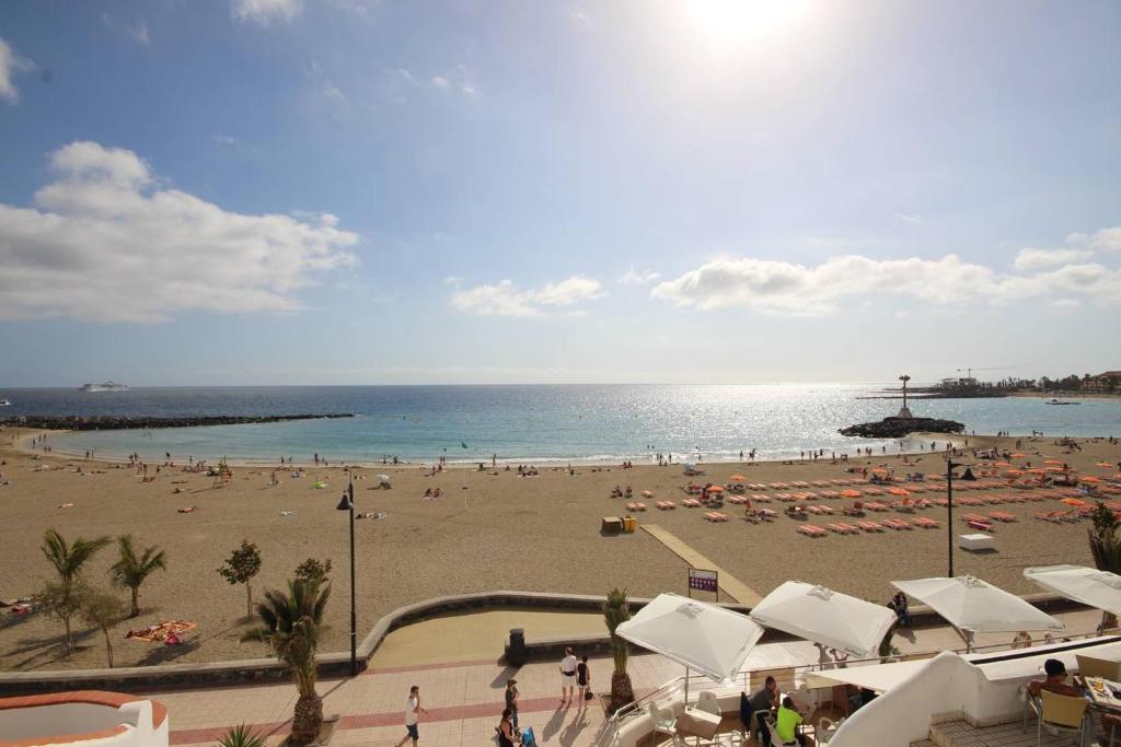 洛斯克里斯蒂亚诺斯Luxury Apartment Cristianos Beachfront的一片拥有众多人的海滩和海洋