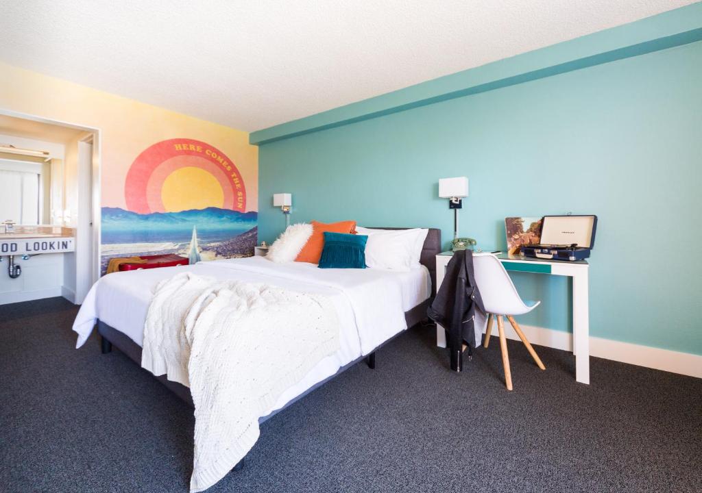 丘拉维斯塔Rambler Motel的卧室配有一张大床,墙上挂有绘画作品