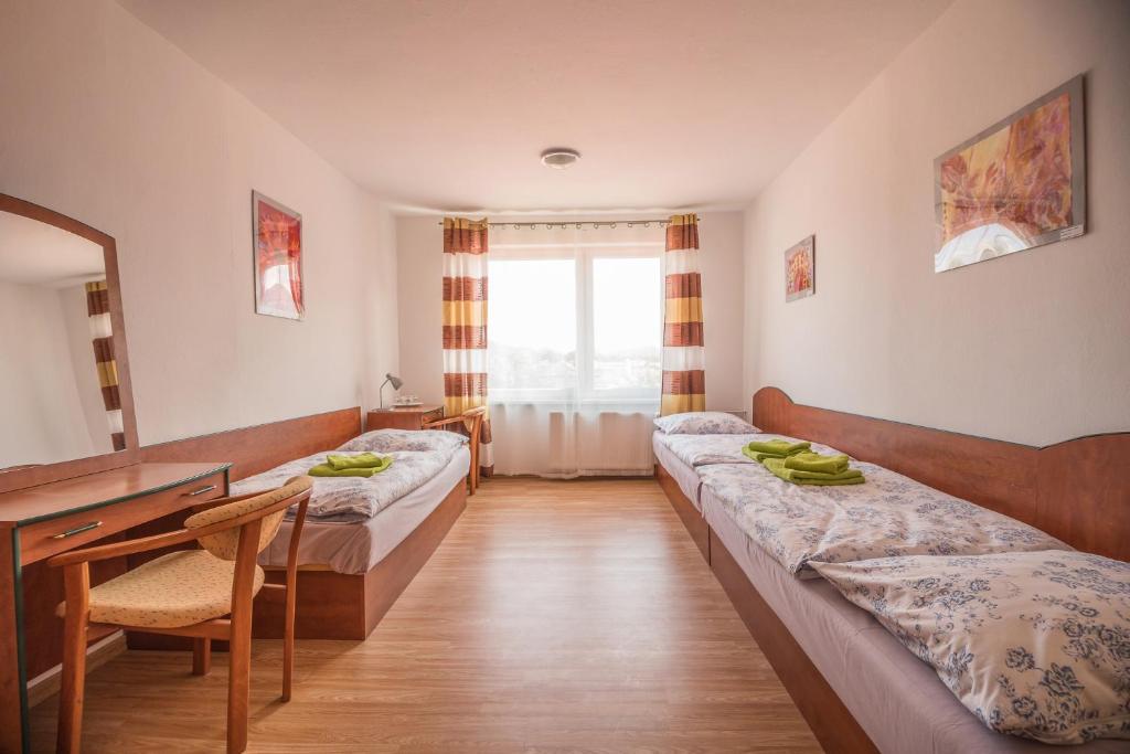 利普托夫堡Hýbadlo的酒店客房设有两张床、一张桌子和一面镜子