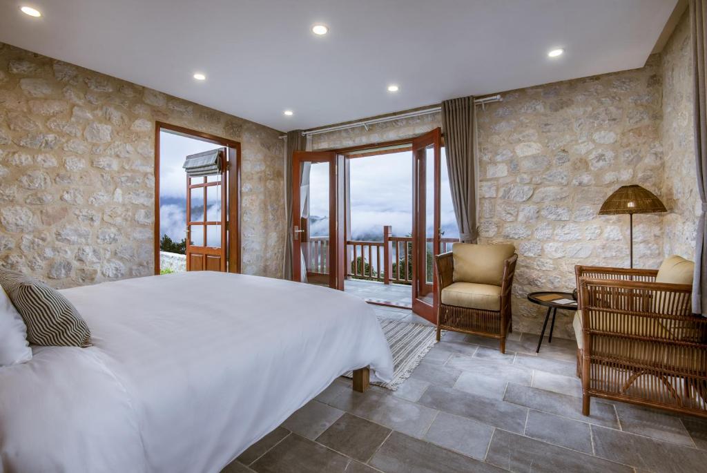 萨帕滔帕斯生态酒店的卧室配有一张白色大床和一把椅子