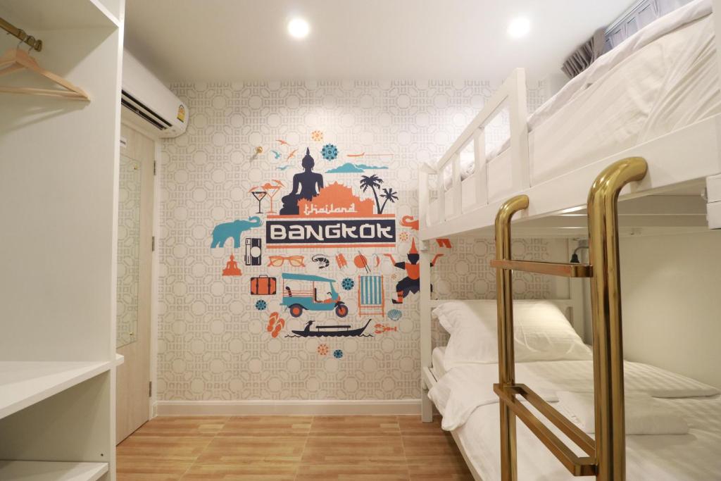 曼谷The LOL Elephant Hostel的一间卧室配有双层床和壁画
