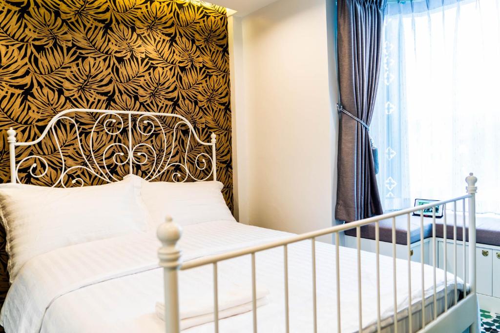 曼谷The LOL Elephant Hostel的一间卧室配有一张带金色床头板的床