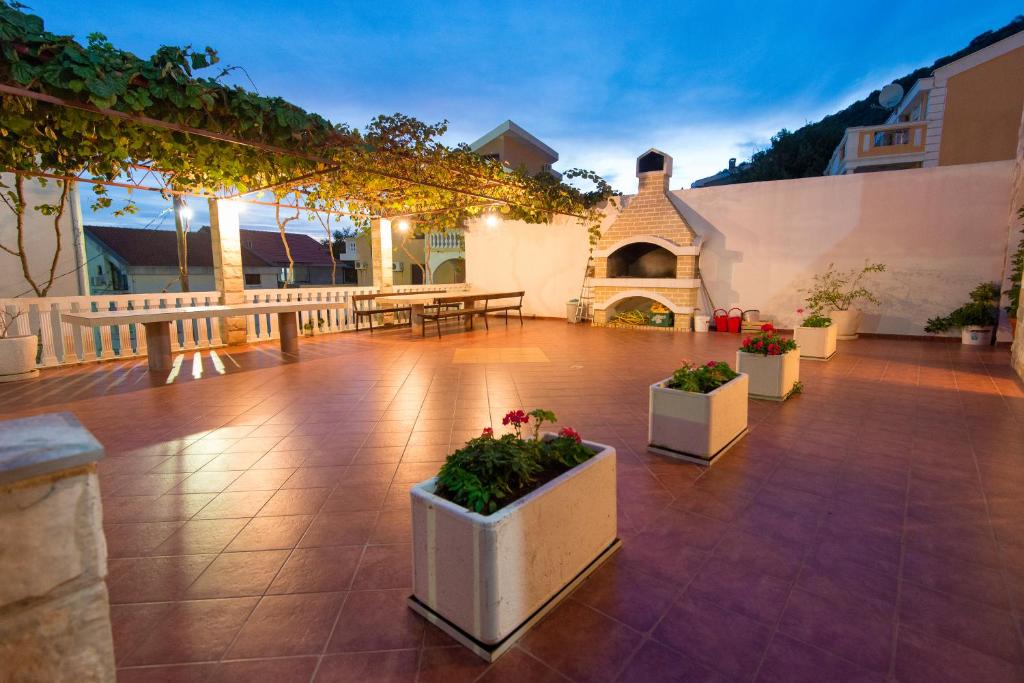 佩特罗瓦纳莫鲁武科蒂奇别墅酒店的庭院里摆放着桌子和盆栽植物