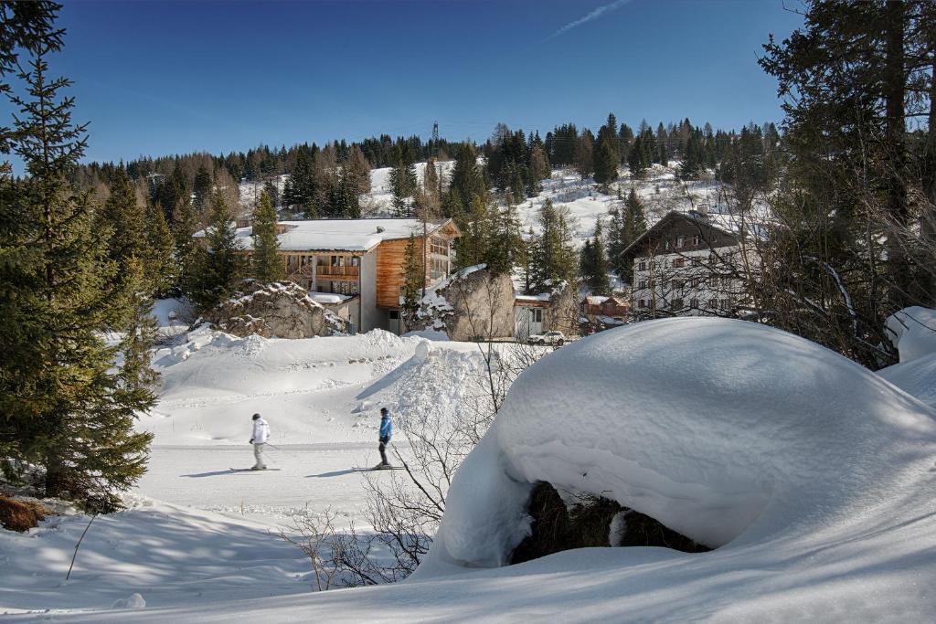 阿拉巴Hotel Garni Elisir的几个人滑雪到雪覆盖的斜坡上