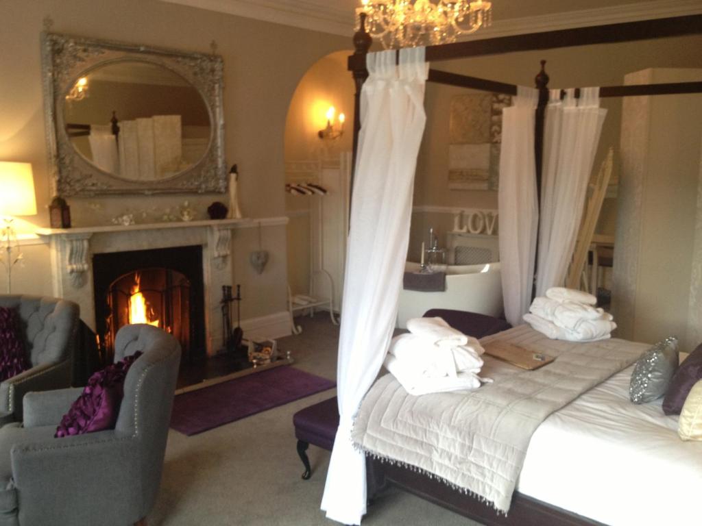里士满城堡庄园酒店的一间卧室配有一张床、一个壁炉和一个镜子