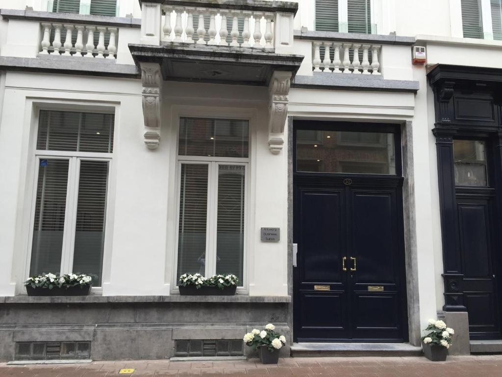 安特卫普Antwerp Town House Accommodations的白色的房子,设有黑色的大门和窗户