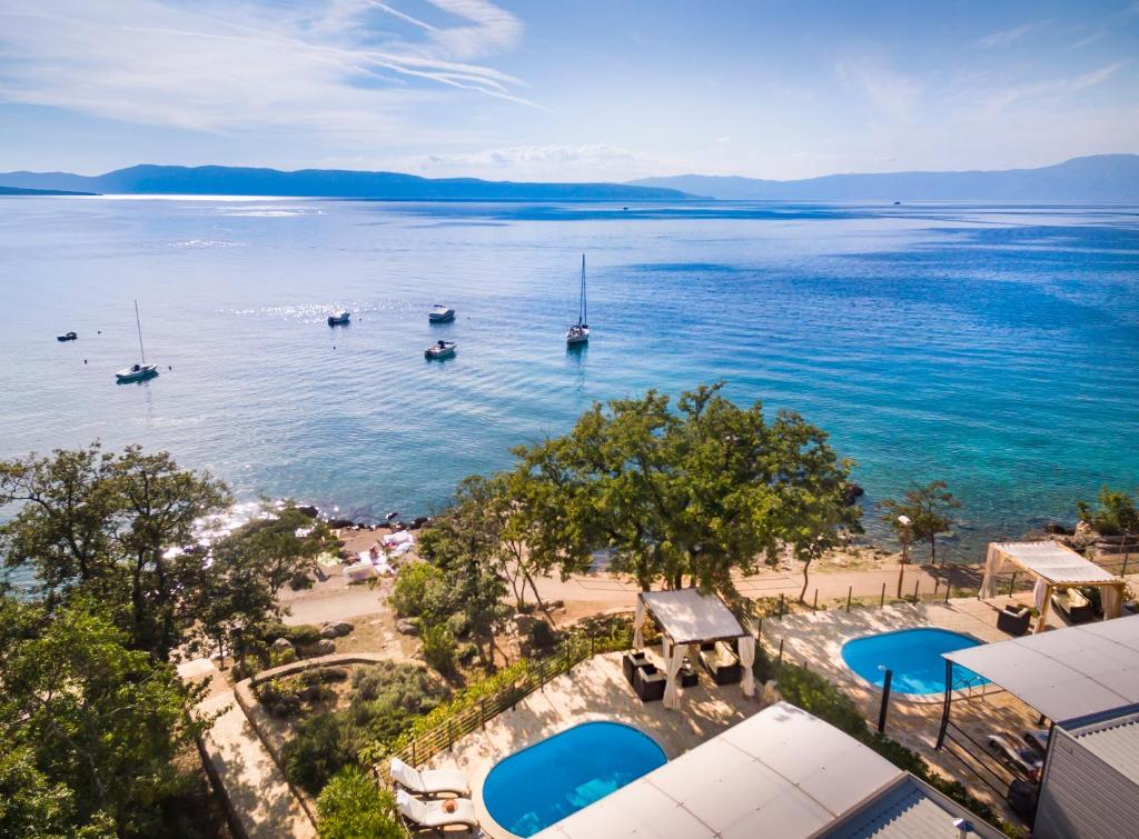 奈维斯Aminess Atea Camping Resort Mobile Homes的享有海滩的空中景色,在水中划船