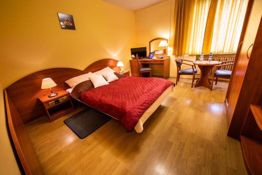 华沙瓦尔德酒店的配有一张床、一张桌子和一张桌子的酒店客房