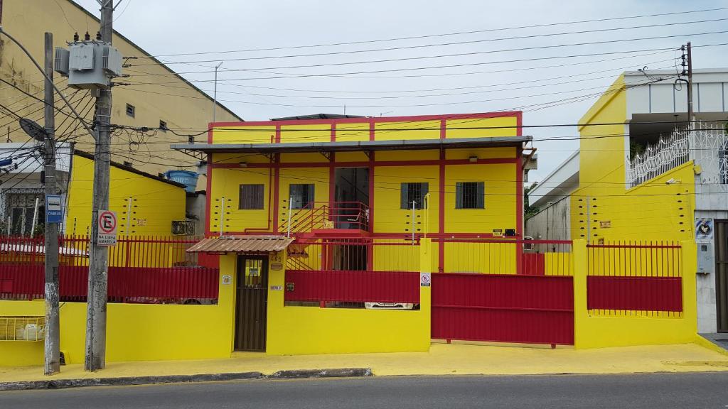 马瑙斯VilaVerin Apartments的街道边的黄色和红色建筑