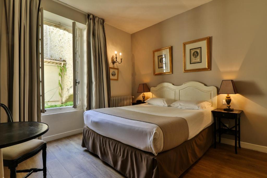 维桑Hotel Du Midi的酒店客房设有床和窗户。