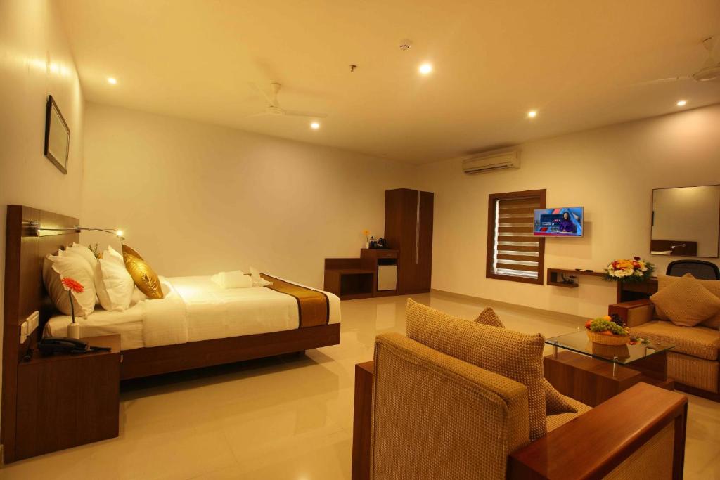 KunnamkulamVictory Inn Park Residency的一间卧室设有一张床和一间客厅。