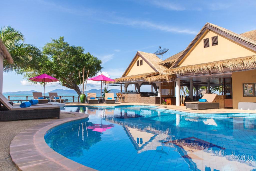 湄南海滩Adarin Beach Resort的度假村的游泳池,配有椅子和遮阳伞