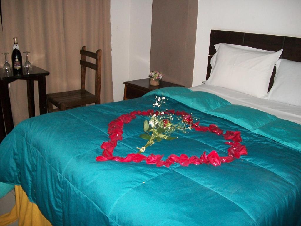 利马Suites El Parque的一张带蓝色毯子的床,上面插着花