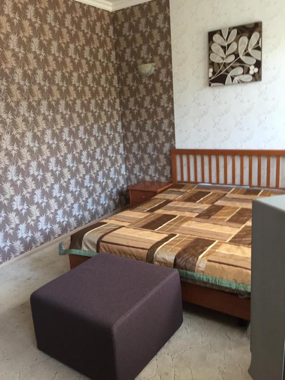 科斯特罗马Guest House on Volga的一间卧室配有一张床和一张搁脚凳