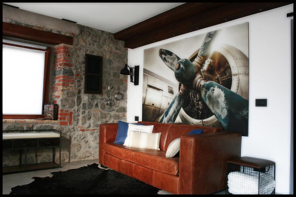 FaedisCasa Vacanze Borc dai Cucs的客厅配有沙发和墙上的绘画