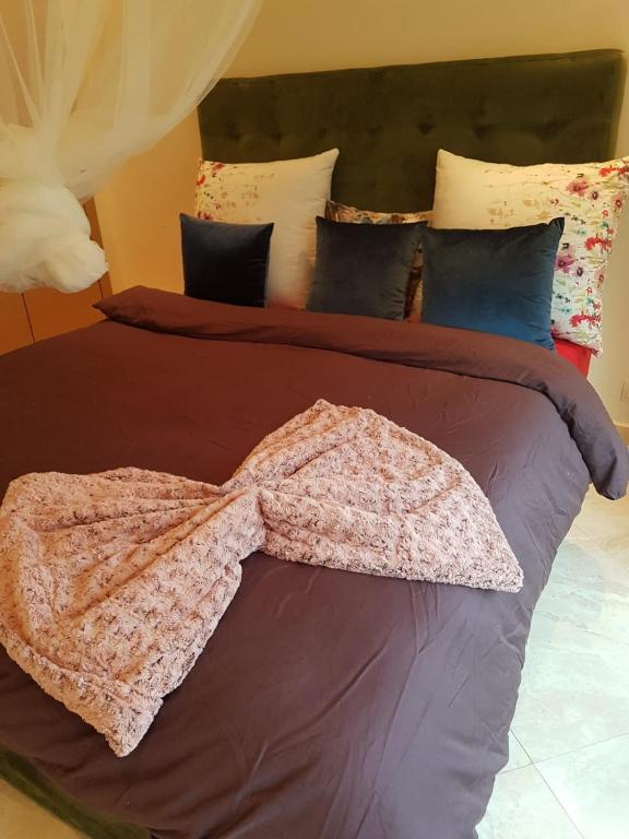 布兹尼盖Residance jardins de bouznika的一张带棕色棉被和枕头的床
