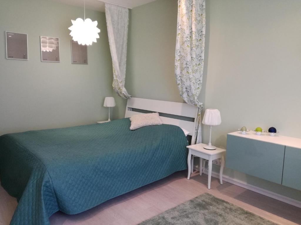 鲍里斯皮尔Sweet-S的一间卧室配有一张床、一张桌子和一个吊灯。