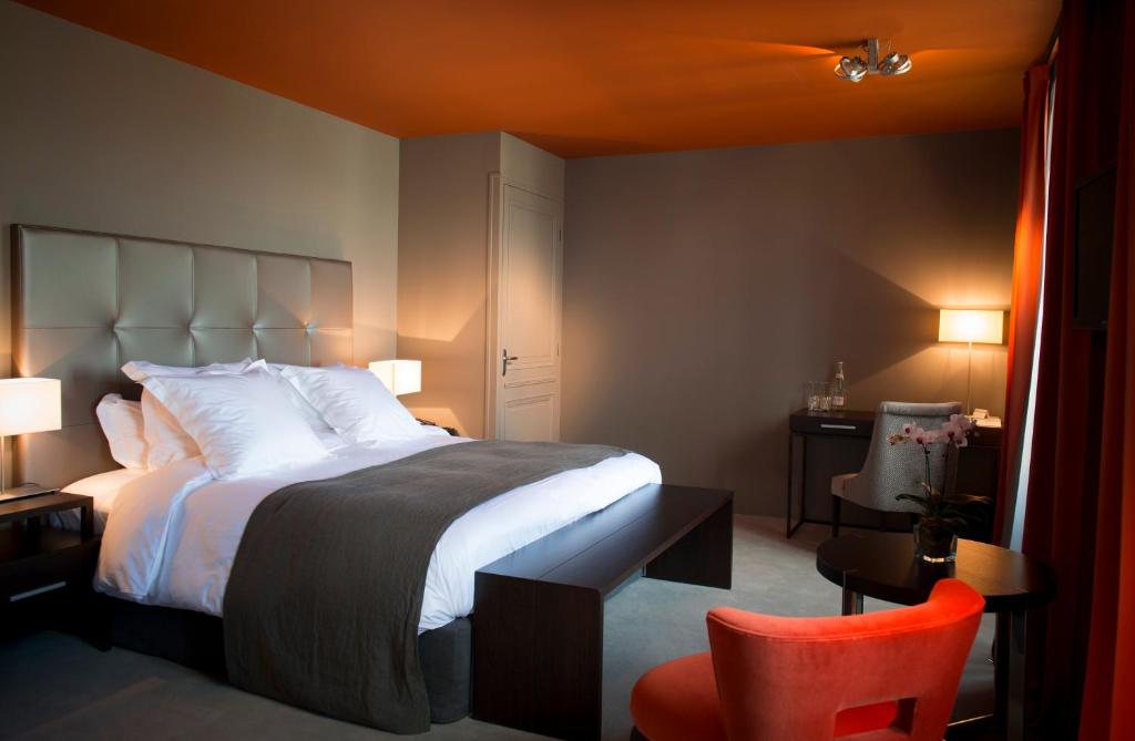 雅尔纳克立格罗酒店的一间卧室配有一张大床和一张红色椅子