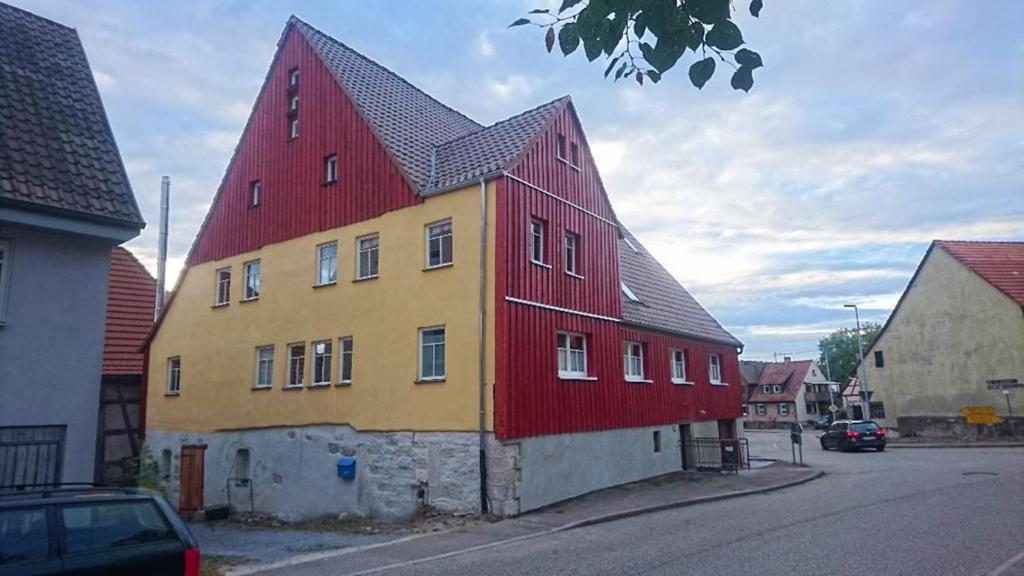 萨森海姆Gemütliche Gästezimmer in einem neu sanierten Fachwerkhaus的红色和黄色的建筑,有红色的屋顶
