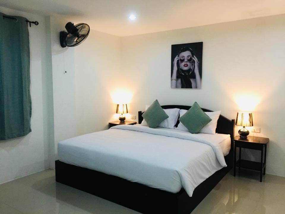 卡马拉海滩Baba Guest House的一间卧室配有一张带两盏灯的大型白色床。