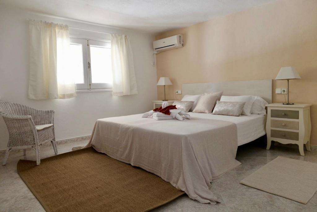 伊斯费古耶拉尔海滩恩卡特德尔里约庄园公寓的卧室配有白色的床和窗户。
