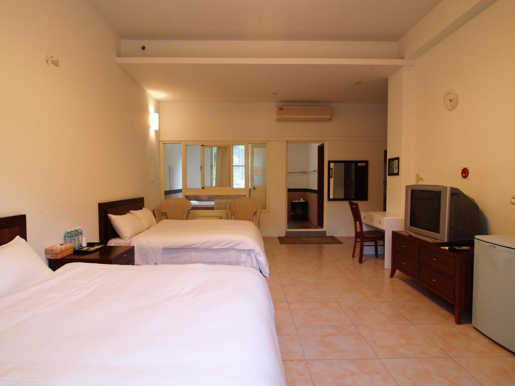 太麻里金仑丹堤温泉会馆的酒店客房设有两张床和电视。
