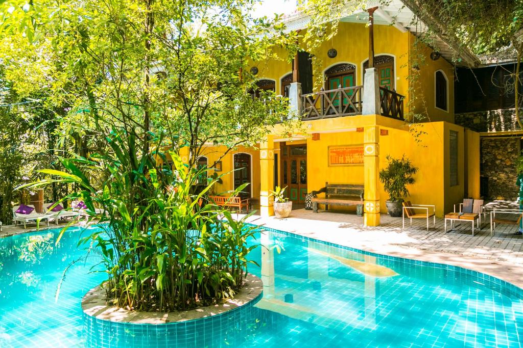 乌纳瓦图纳塔巴派尼度假酒店的黄色房子前面的游泳池