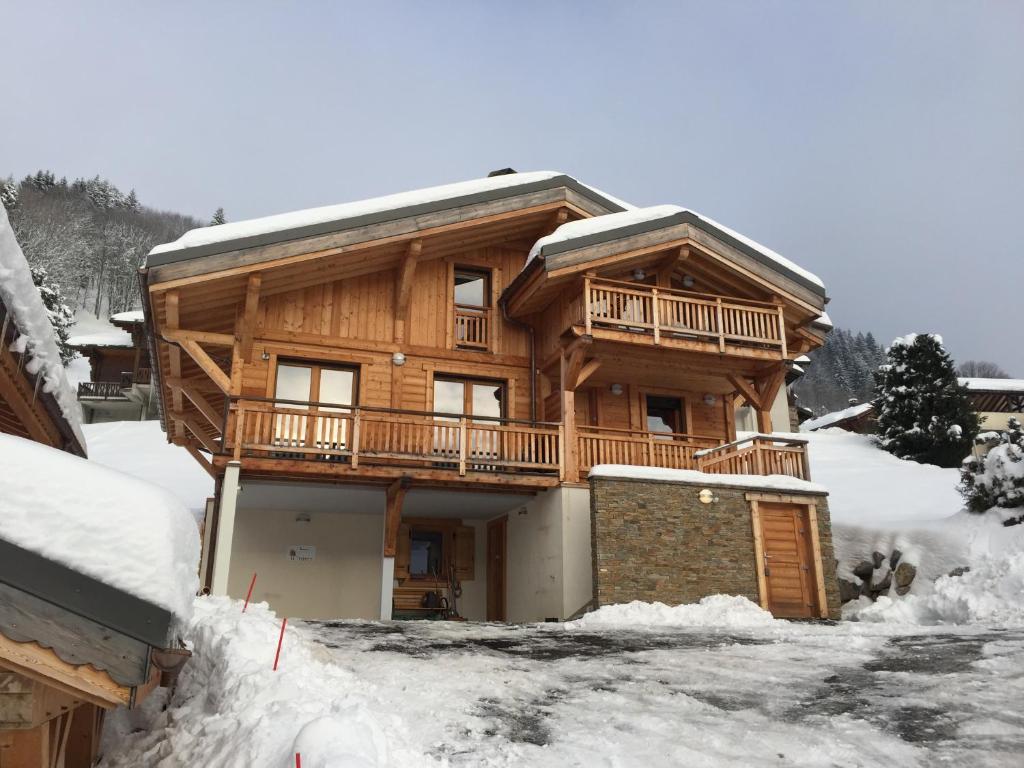 莱热ORTA Chalet的雪地里的小木屋,有车道