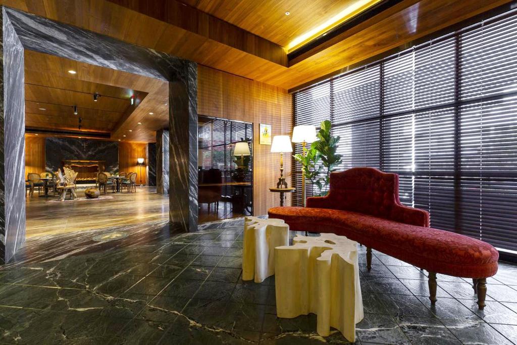 台中市薆悦酒店五权馆的大堂设有红色椅子和大窗户