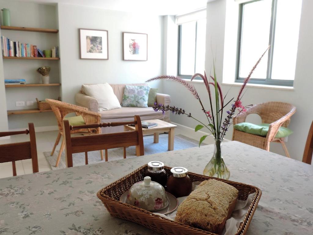 米德希特本-古里安沙漠玫瑰公寓的客厅配有一张桌子和一篮子食物
