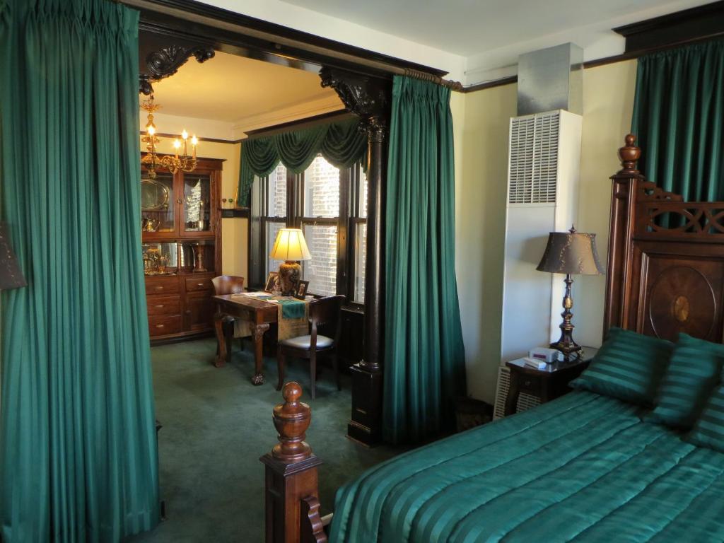 芝加哥美国桥港马球住宿加早餐旅馆的一间卧室配有绿色窗帘、一张床和一张书桌